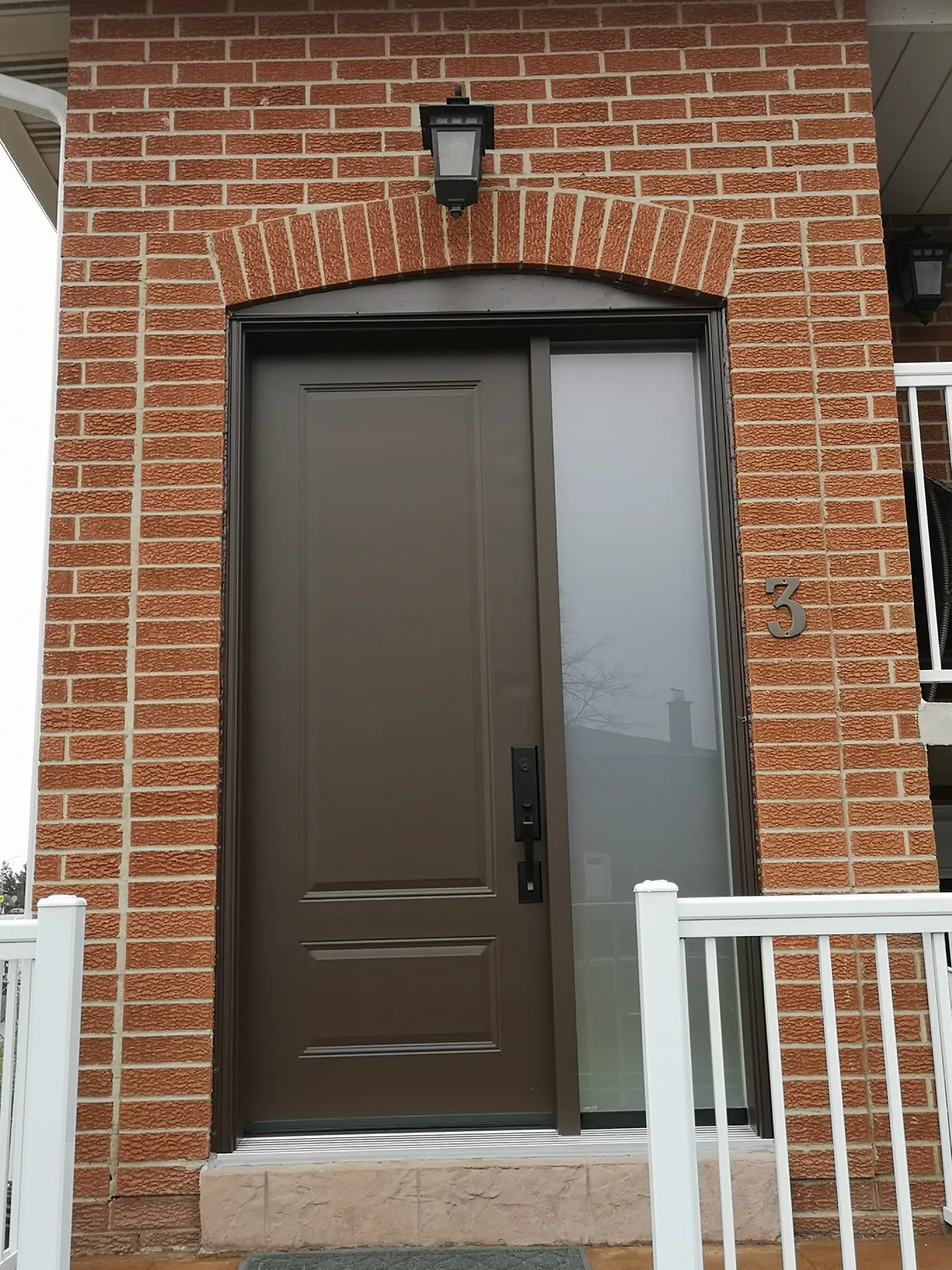 Brown raised-panel door with sidelite