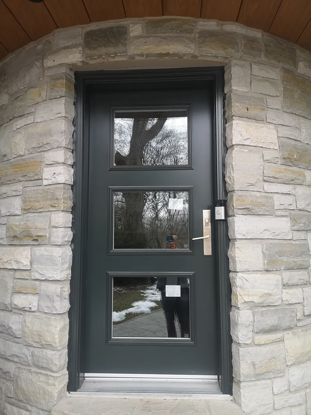Dark green door, three glass lites, stone surround