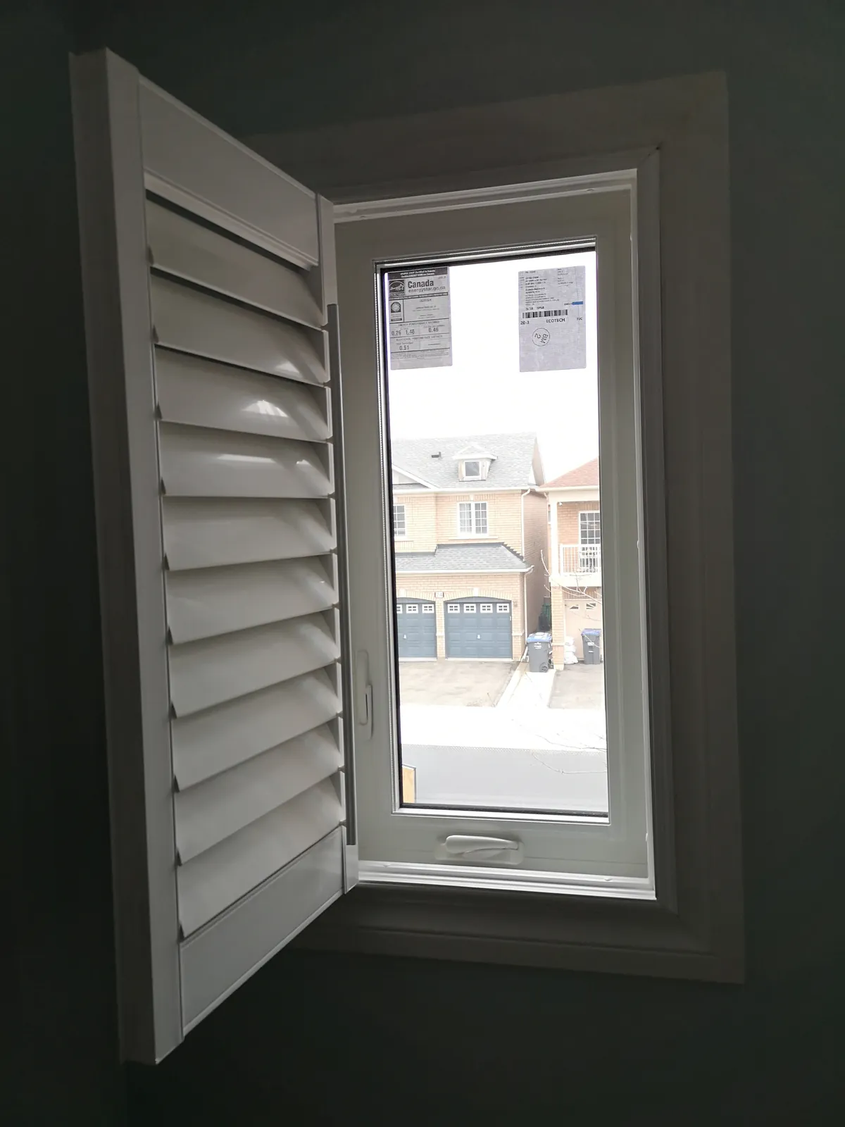 White interior shutters on casement window