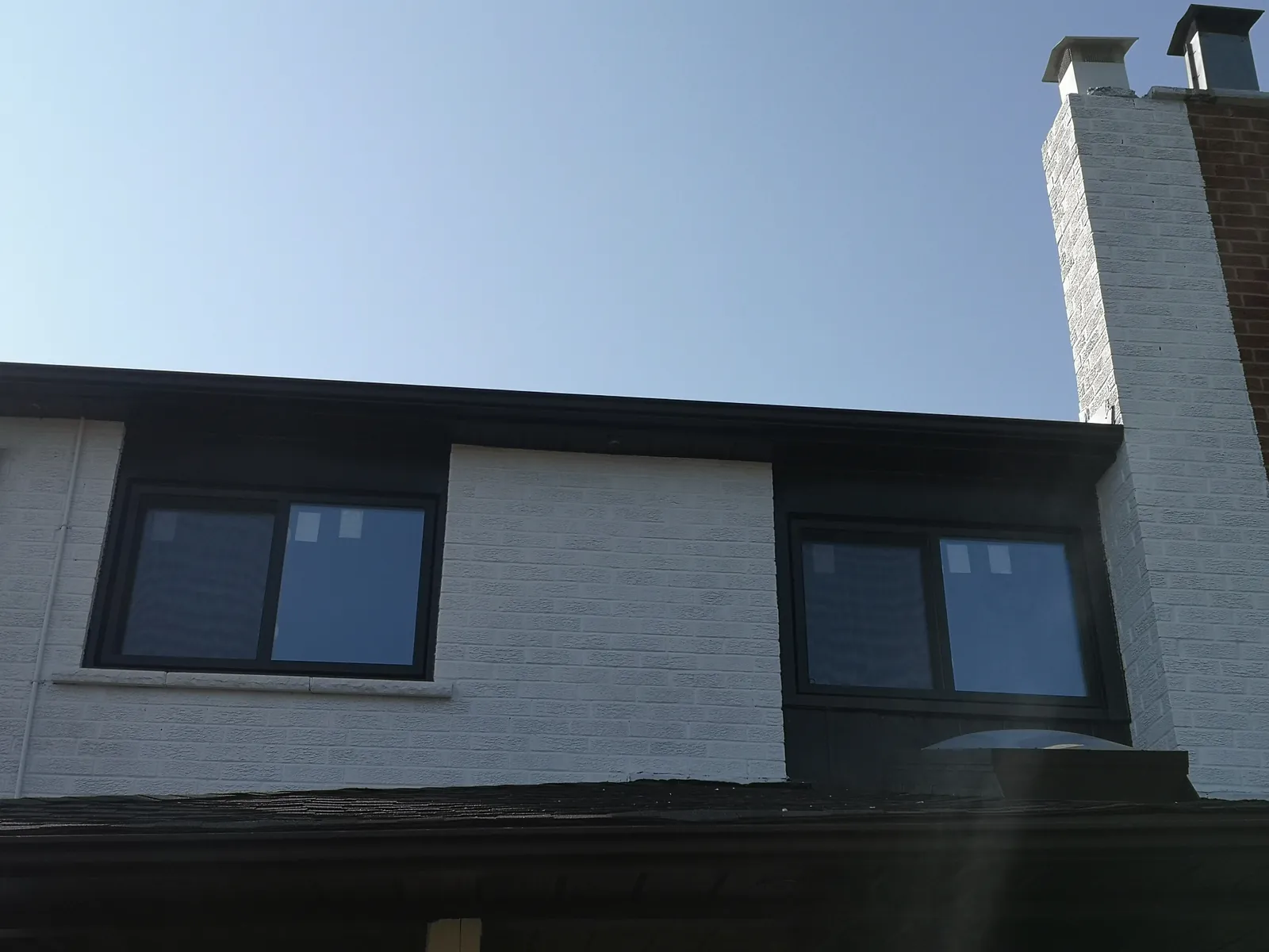 Black-frame windows, painted brick