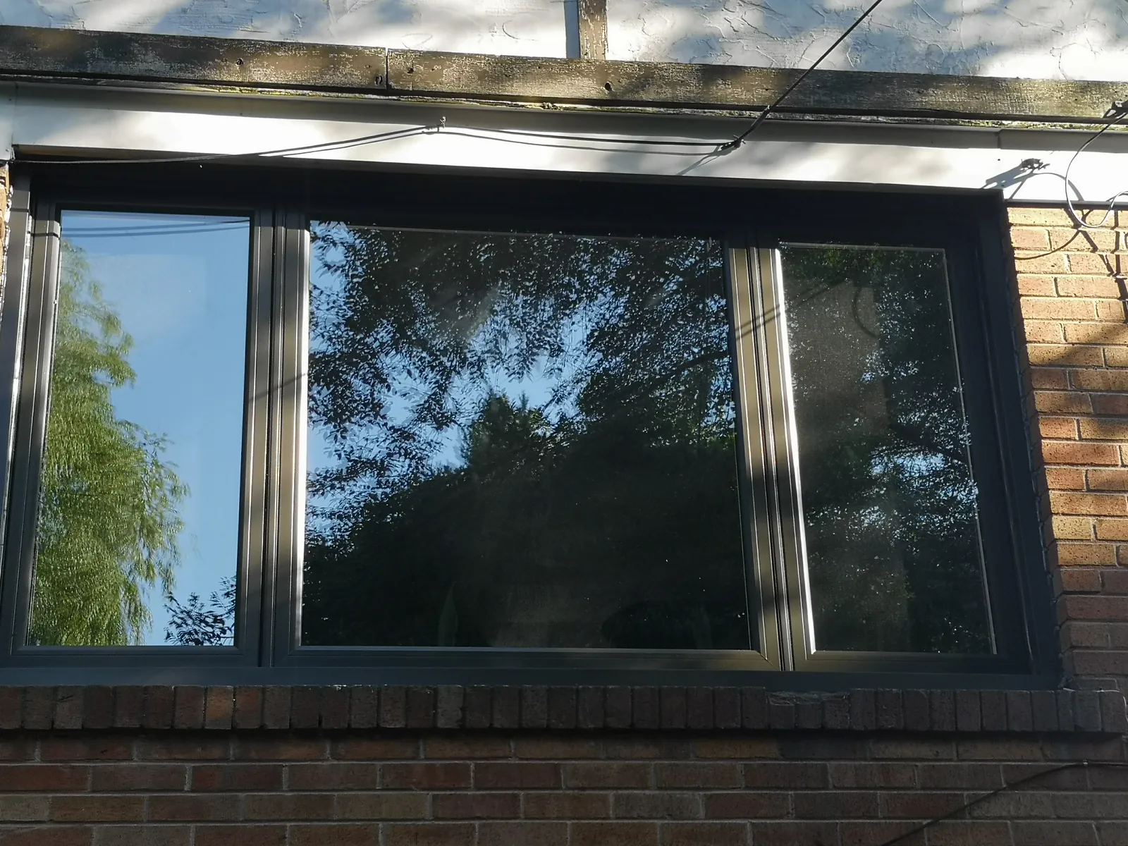 Black triple window, brick exterior